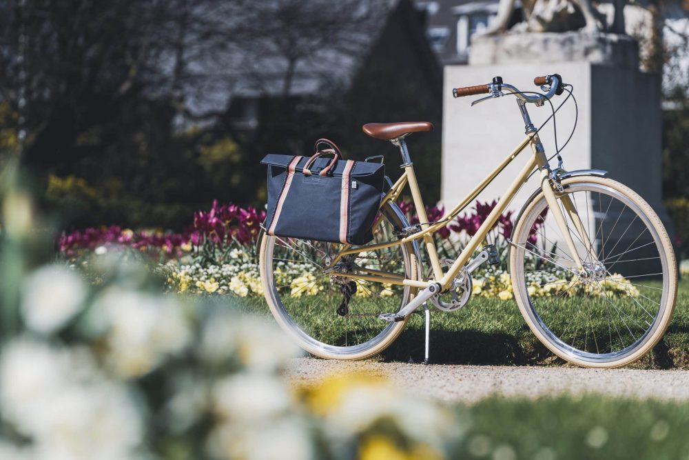 Sacoche vélo étincelle bleu et rose attachée au vélo dans un parc