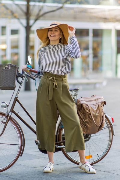 femme élégante à vélo avec chapeau et sacoche vélo